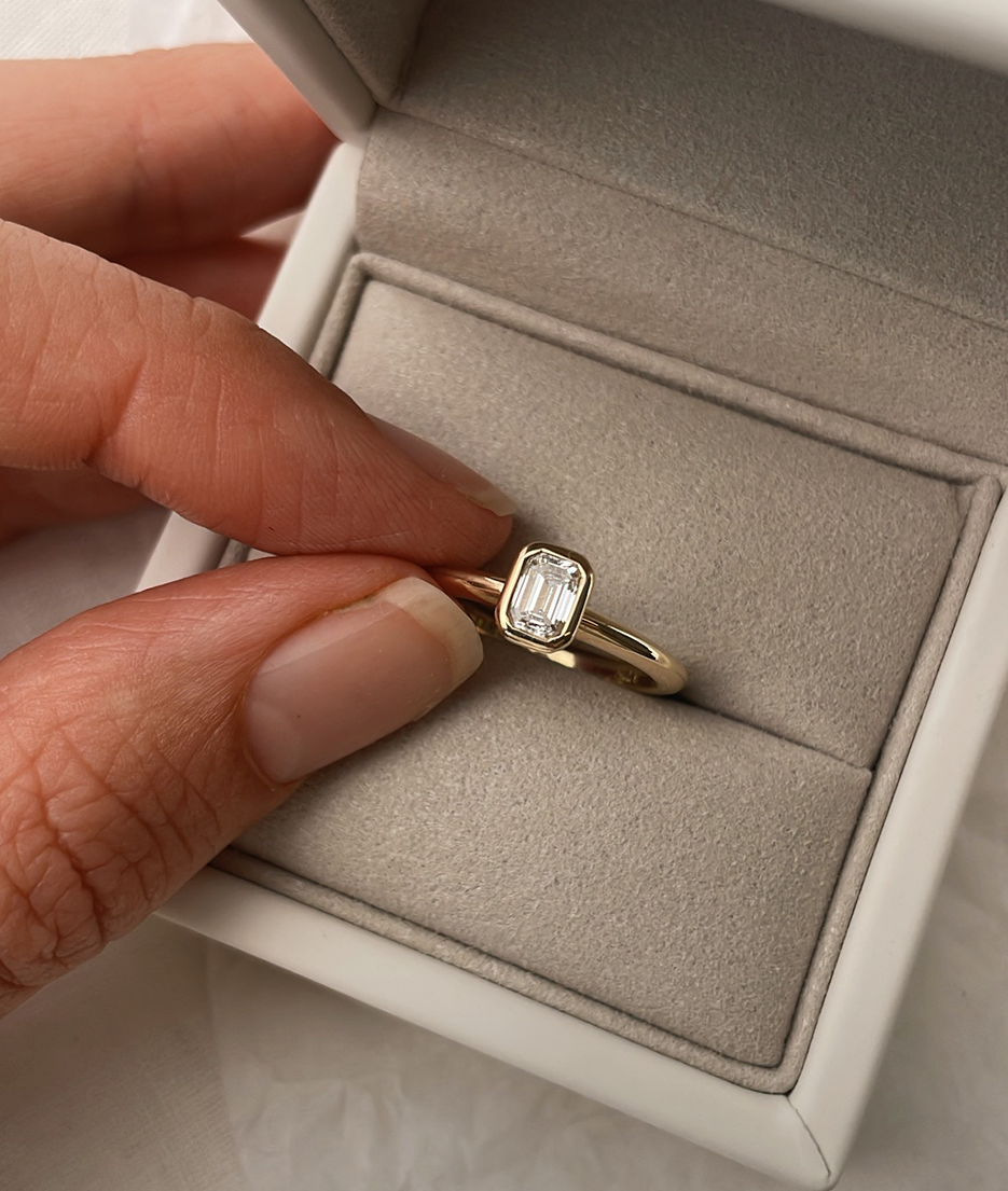 Emerald Cut Diamond bezel set Solitaire ring, cast in solid Gold. Handcrafted to order in Sydney Australia. Minimal Diamond Engagement ring ideal for stacking with other bands. Custom engagement and wedding rings.