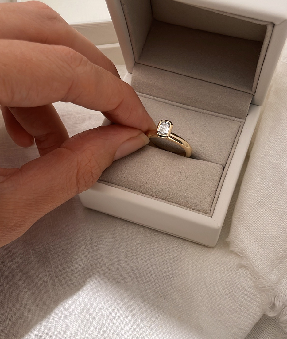 Emerald Cut Diamond bezel set Solitaire ring, cast in solid Gold. Handcrafted to order in Sydney Australia. Minimal Diamond Engagement ring ideal for stacking with other bands. Custom engagement and wedding rings.