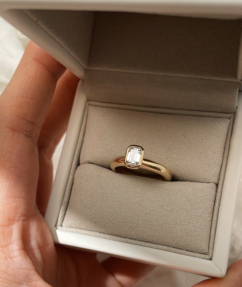 Emerald Cut Diamond bezel set Solitaire ring, cast in solid Gold. Handcrafted to order in Sydney Australia. Minimal Diamond Engagement ring ideal for stacking with other bands. Custom engagement and wedding rings.