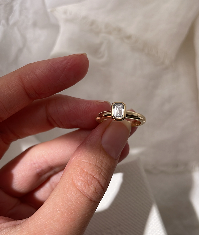 Emerald Cut Diamond bezel set Solitaire ring, cast in solid Gold. Handcrafted to order in Sydney Australia. Minimal Diamond Engagement ring ideal for stacking with other bands. Custom engagement and wedding rings.