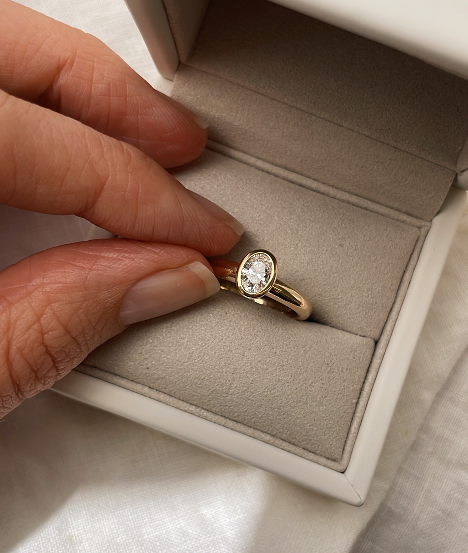 Hand carved oval bezel set Solitaire ring, cast in solid Gold. Handcrafted to order in Sydney Australia. Minimal Diamond Engagement ring ideal for stacking with other bands. Custom engagement and wedding rings.