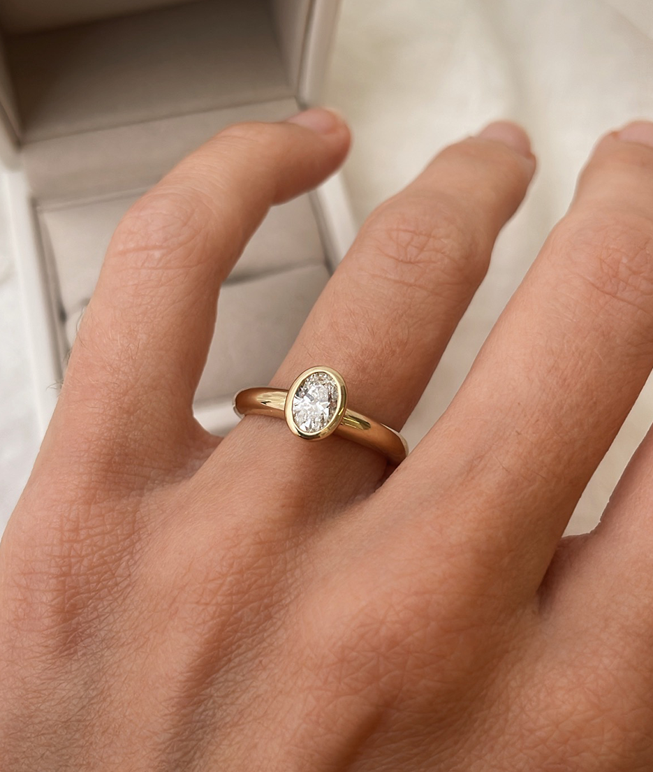 Hand carved oval bezel set Solitaire ring, cast in solid Gold. Handcrafted to order in Sydney Australia. Minimal Diamond Engagement ring ideal for stacking with other bands. Custom engagement and wedding rings.