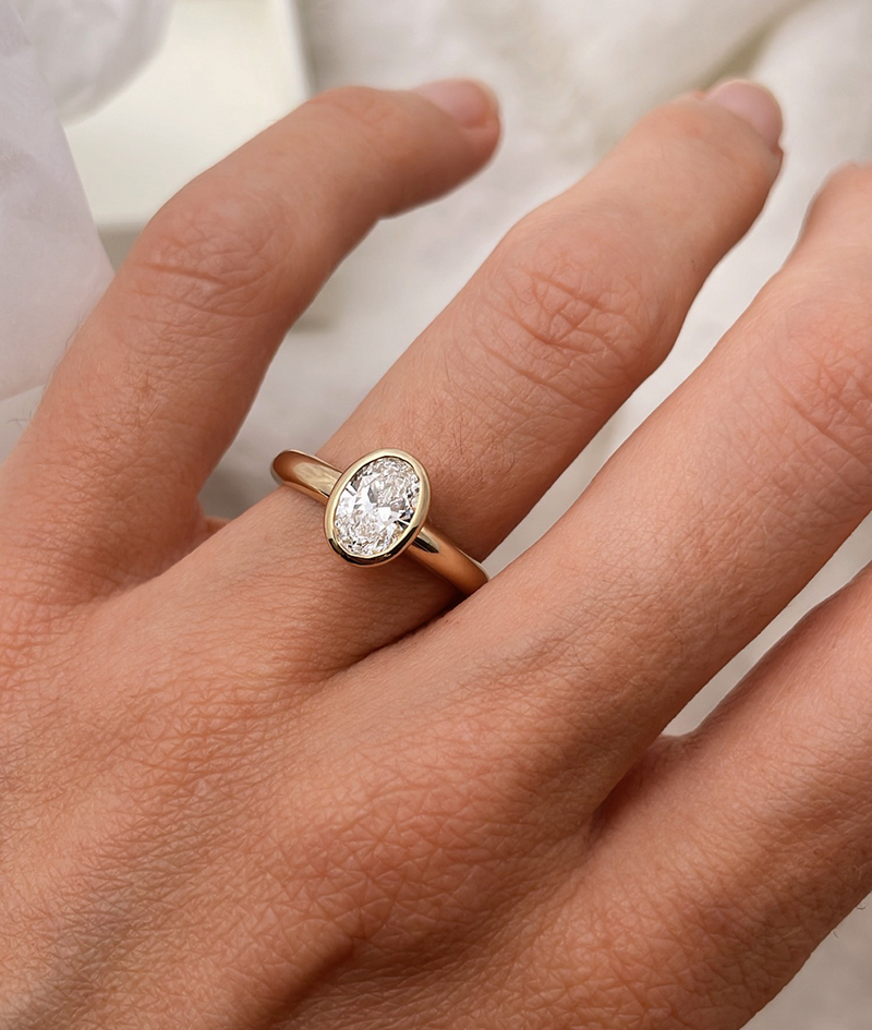 Hand carved oval bezel set Solitaire ring, cast in solid Gold. Handcrafted to order in Sydney Australia. Minimal Diamond Engagement ring ideal for stacking with other bands. Custom engagement and wedding rings.