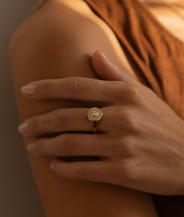 Handmade solid gold womens signet ring featuring a conflict-free Diamond. Round diamond bezel set in the centre of the signet face, cast in solid Gold. Made to order in Sydney Australia. Bespoke and Custom rings for the modern woman and bride.