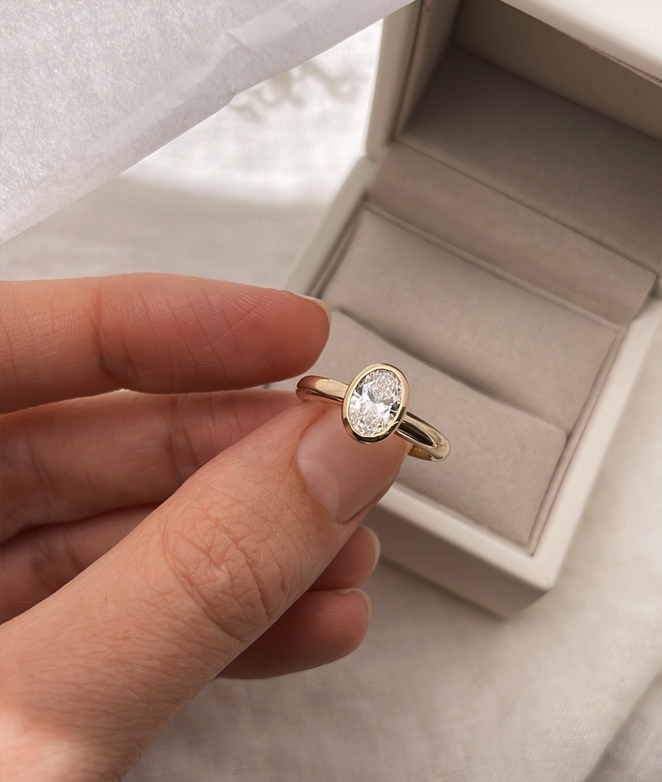 Hand carved oval bezel set Solitaire ring, cast in solid Gold. Handcrafted to order in Sydney Australia. Minimal Diamond Engagement ring ideal for stacking with other bands. Custom engagement and wedding rings.