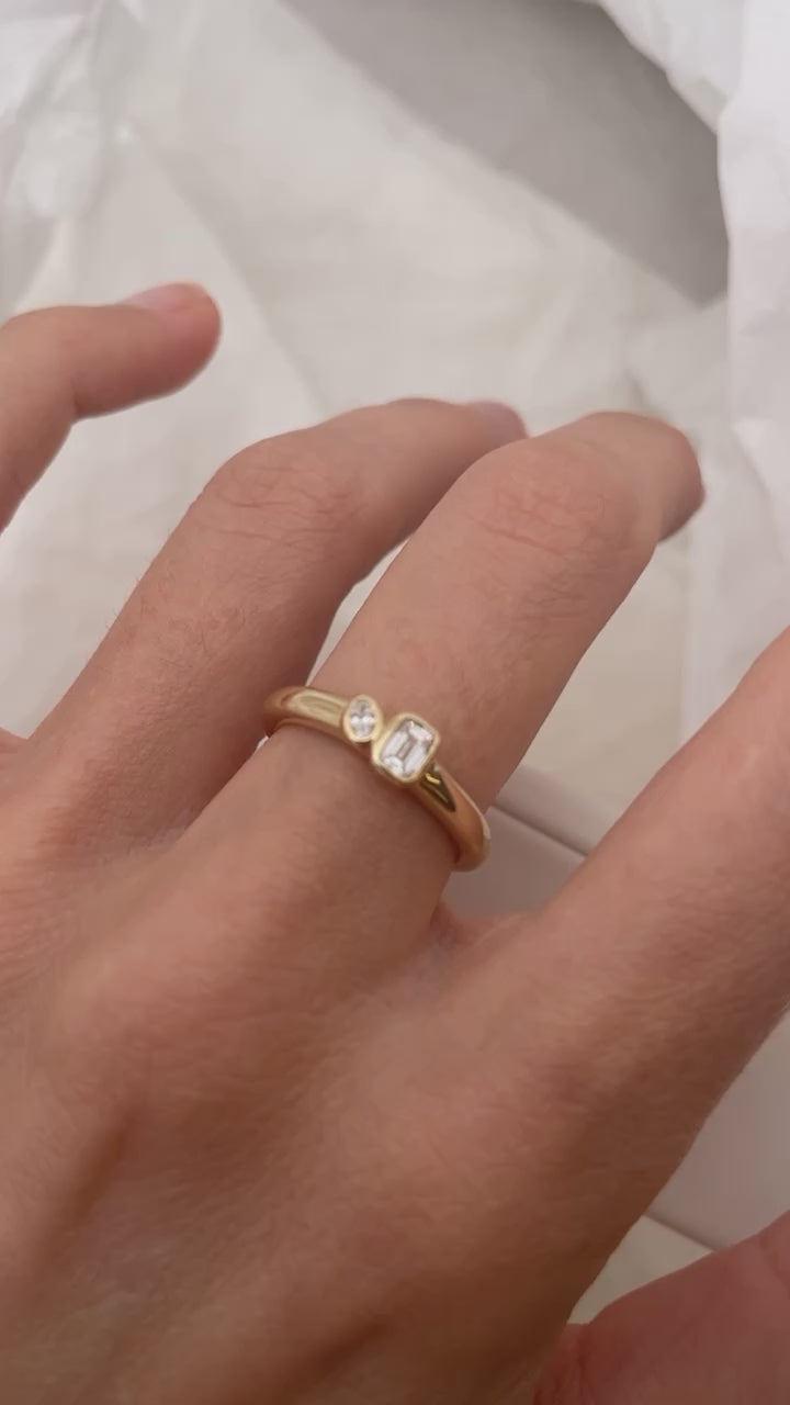 Load video: Mini Oval and Emerald Toi et Moi ring featuring bezel set oval and emerald diamonds, cast in solid Gold. Mindful jewellery and unique engagement rings for the modern woman and bride. Made in Sydney Australia 