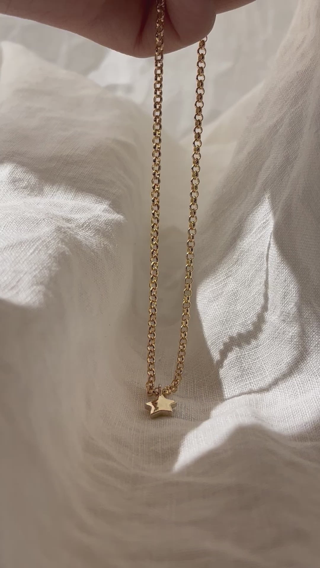 Load video: Tiny Star Charm necklace. Hand carved pendant with a flush set Diamond, Ruby, Emerald or Sapphire. Personalise your gold charm necklace with stones and engraving. Fine jewellery handmade in Sydney.