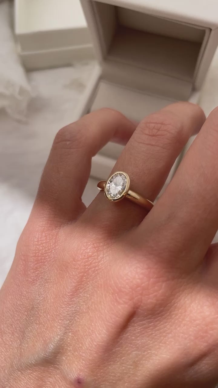 Load video: Hand carved oval bezel set Solitaire ring, cast in solid Gold. Handcrafted to order in Sydney Australia. Minimal Diamond Engagement ring ideal for stacking with other bands. Custom engagement and wedding rings.