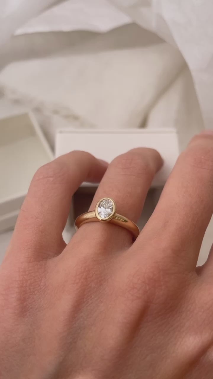 Hand carved oval bezel set Solitaire ring, cast in solid Gold. Handcrafted to order in Sydney Australia. Minimal Diamond Engagement ring ideal for stacking with other bands. Custom engagement and wedding rings.
